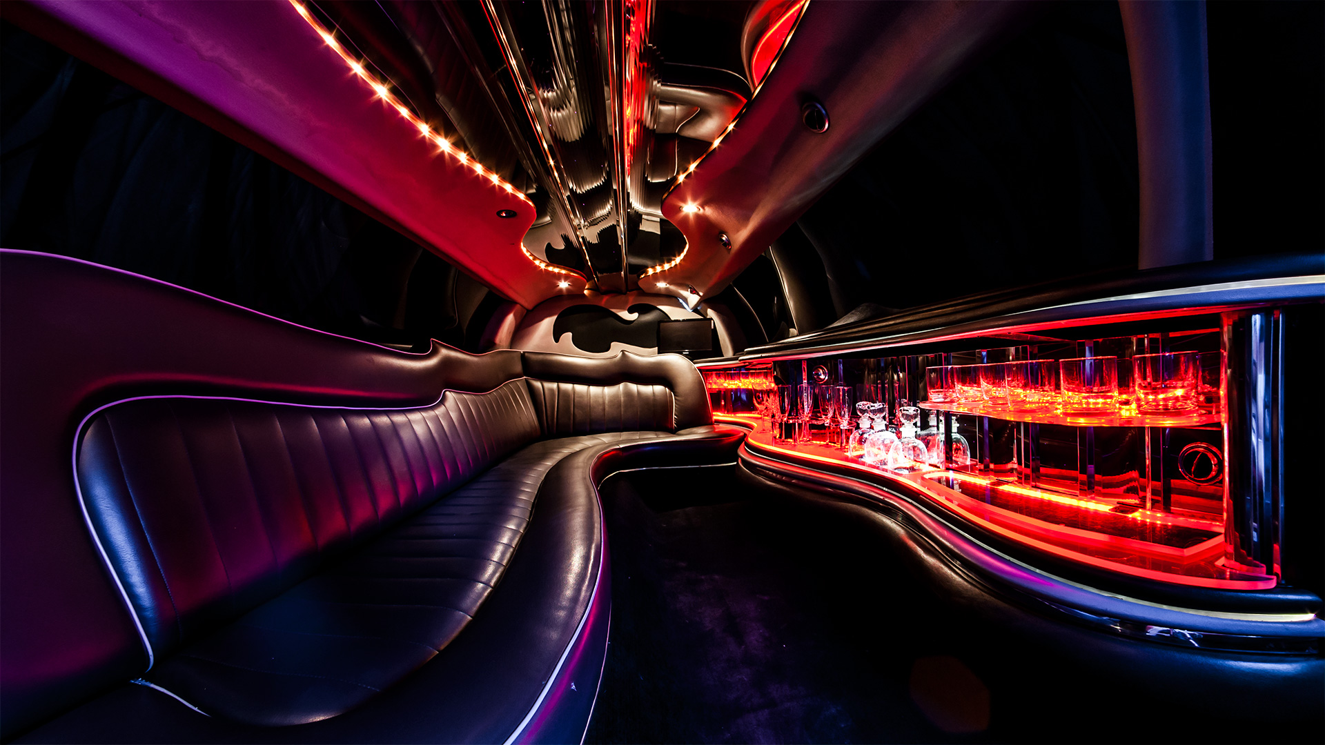 Wnętrze luksusowej limuzyny z długą skórzaną kanapą i kolorowym podświetleniem